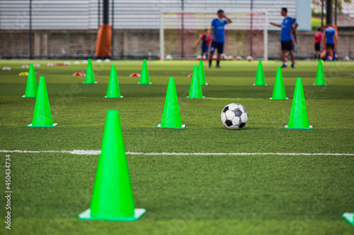Soccer ball tactics cone on grass field with for training background