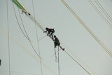 Male walking on the line electricity Installation of high-voltage electricity poles the work at height risk wear