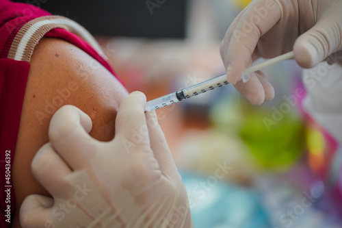 Doctor holding syringe and  make injection Covid-19 or coronavirus vaccine to patient