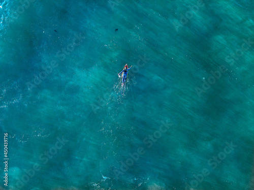 surfer girl paddles out to sea on surfboard