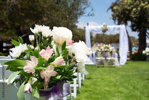 close up of a floral arrangement in a wedding ceremony setup outdoors