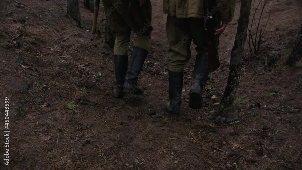 Two soldiers of world war ii walking in a forest with rifles and helmets and boots Two soldiers of world war ii walking in a forest with rifles and helmets and boots