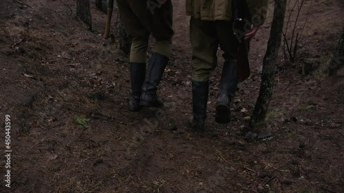 Two soldiers of world war ii walking in a forest with rifles and helmets and boots photo