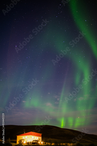 Aurora Borealis  or Northern Lights  above a building near Lake M  vatn  Reykjahl      north Iceland