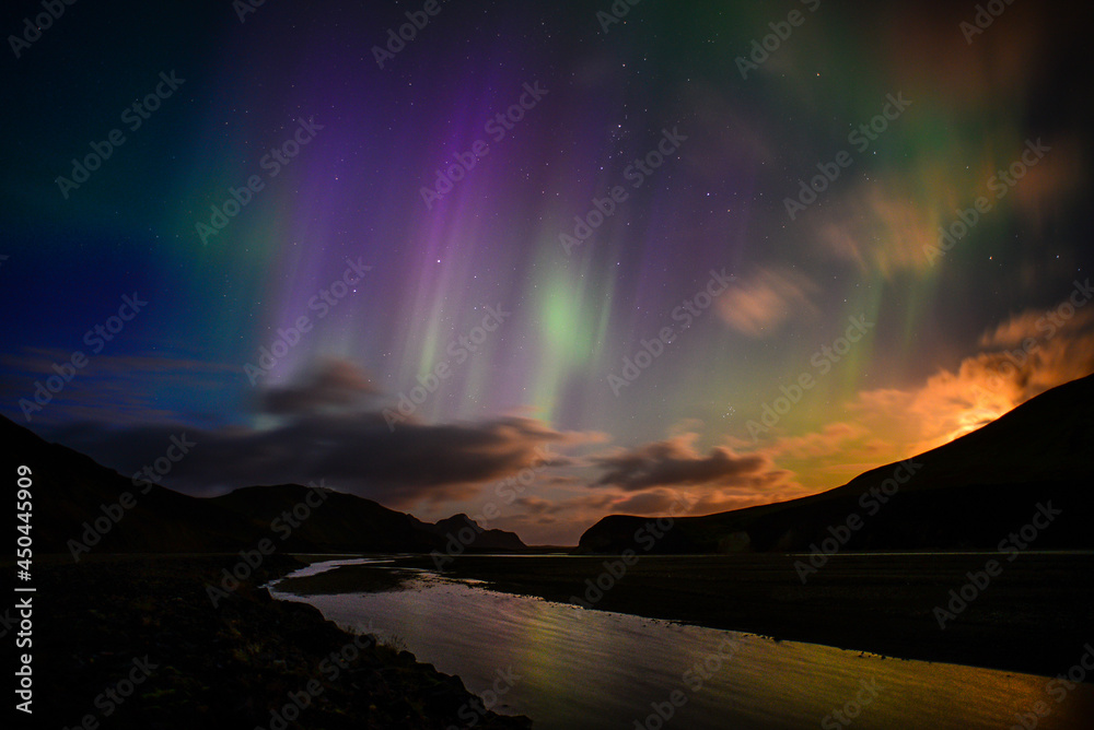 Aurora Borealis, or Northern Lights, fluttering above a river and the volcanic landscape of Landmannalaugar, Fjallabak Nature Reserve, Central Highlands, Iceland