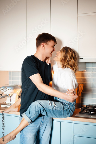 Caucasian couple smiling and embracing on cozy kitchen © WellStock