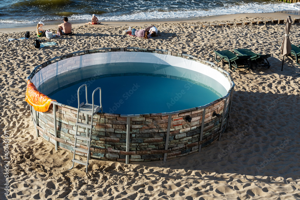 Round pool near the sea, on the beach for vacationers.
