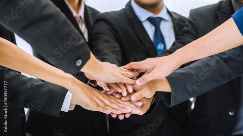 Businesspeople team take stack hands together after success deal with cooperation at meeting. Business team applauding their partnership after success on business financial investment concept.