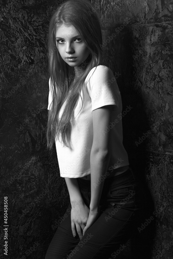 Fototapeta premium Stylish dressed stunning woman posing in a dark room