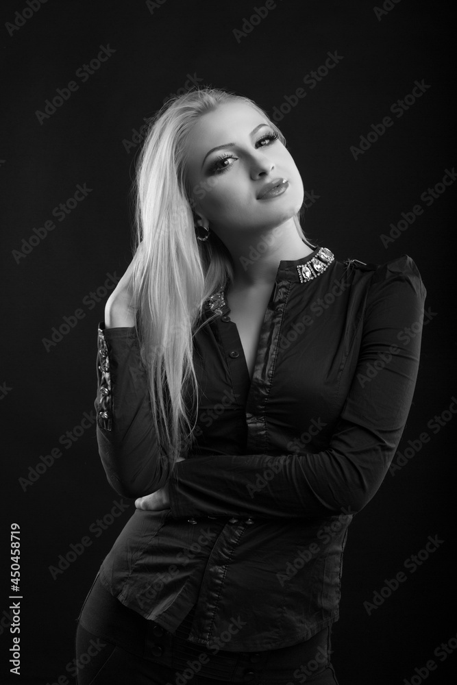 Attractive blond lady with perfect makeup and long straight hair wears blouse, posing at studio. Black and white sho Attractive blond lady with perfect makeup and long straight hair wears blouse, posing at studio. Black and white sho