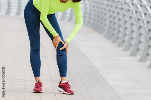 Young woman was running along the embankment and suddenly felt a sharp pain in the knee joint due to a dislocation or rupture of the meniscus