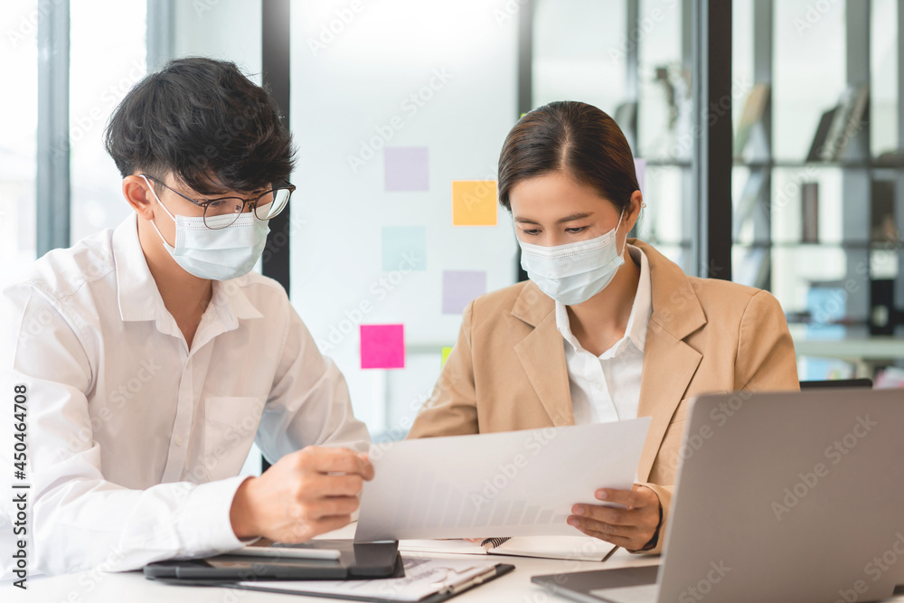 two coworkers helping each other to revise the contract before signing signature carefully with the hygienic protection two coworkers helping each other to revise the contract before signing signature carefully with the hygienic protection
