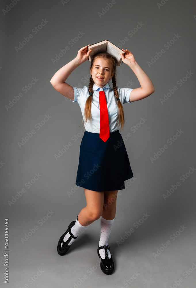 12 year old girl school Girl 12 years old in school uniform with book above head ...