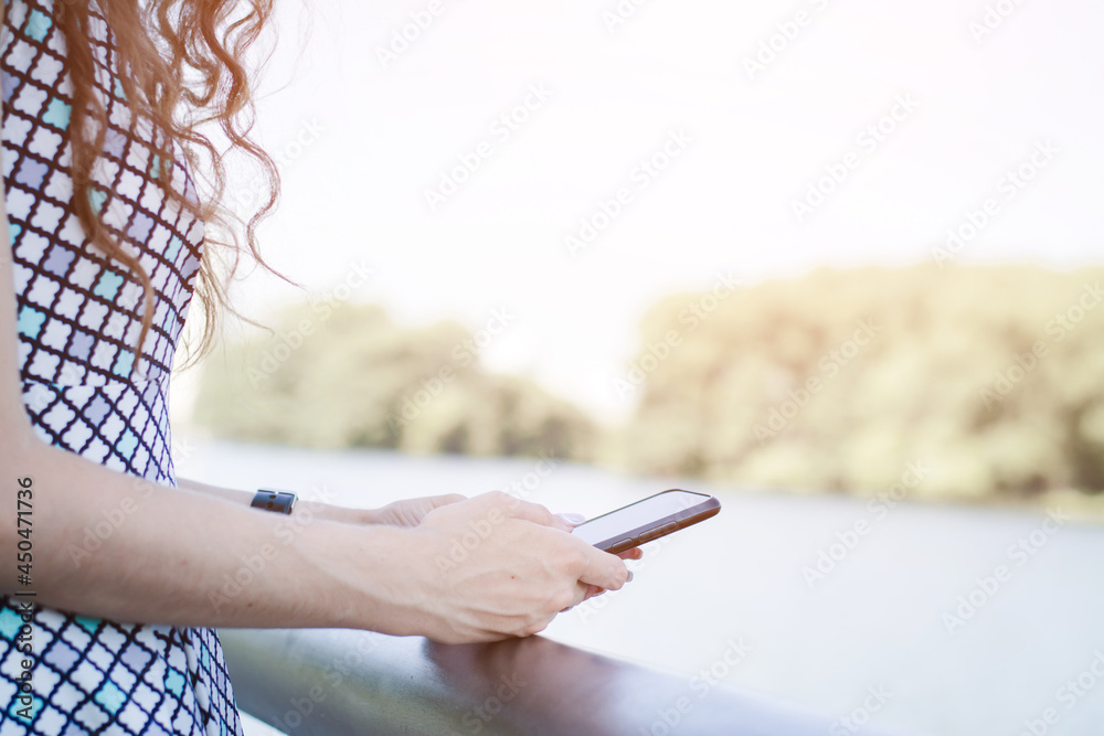 Woman using smartphone at sunset