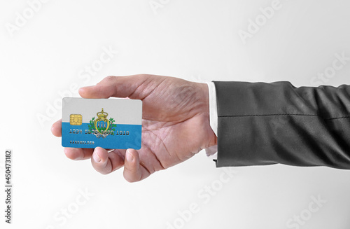 Bank credit plastic card with flag of San Marino holding man in elegant suit