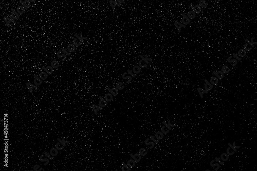 Falling snow on a black background. small particles with bright dots starry sky. Сhaotic white bokeh. light spots texture. abstract.