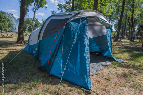 Camping tent at wild campsite surrounding the pine forest on summer daylight