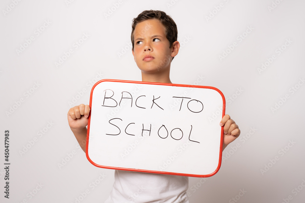 Smiling male student holding signboard isolated over white background. Back to school concept.