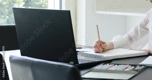 woman in white blouse works or studies drawing with a computer