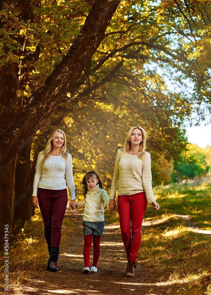 Little girl with two elder sisters walking outdoor in autumn forest Little girl with two elder sisters walking outdoor in autumn forest