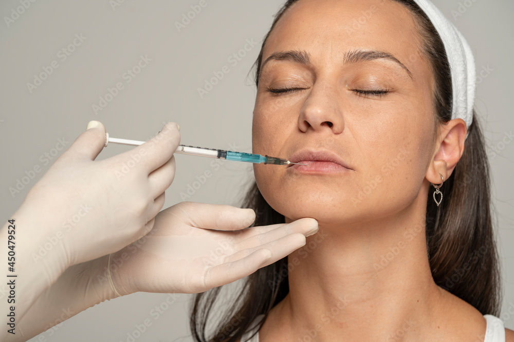 young satisfied woman on a lip filler injection procedure young satisfied woman on a lip filler injection procedure