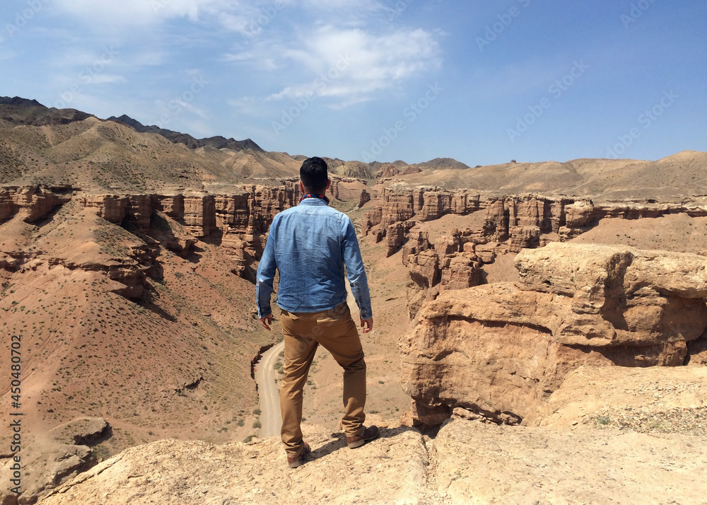 Man in denim shirt overlooking Charyn Canyon in Kazakhstan Man in denim shirt overlooking Charyn Canyon in Kazakhstan