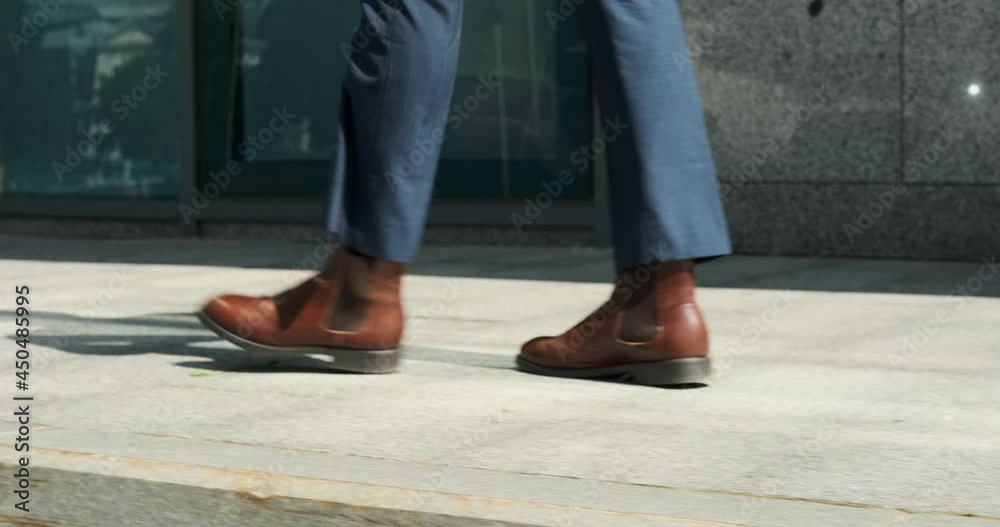 Low section of businessman walking outside office building Low section of businessman walking outside office building