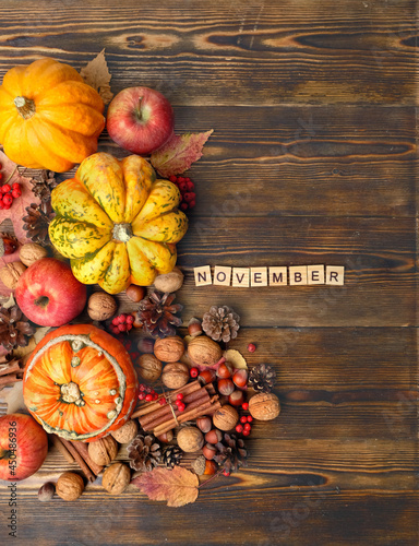 Ripe pumpkins, cones, nuts, apples on wooden table. November time. autumn season, harvesting. thanksgiving holiday concept. flat lay