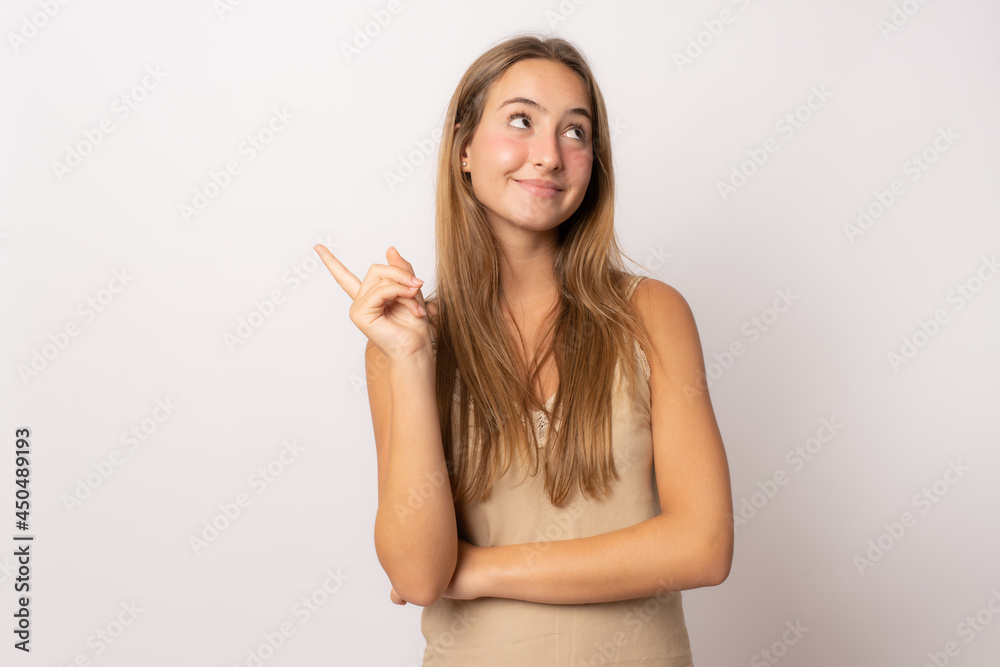 Young smiling girl pointing finer up isolated over white background. Young smiling girl pointing finer up isolated over white background.