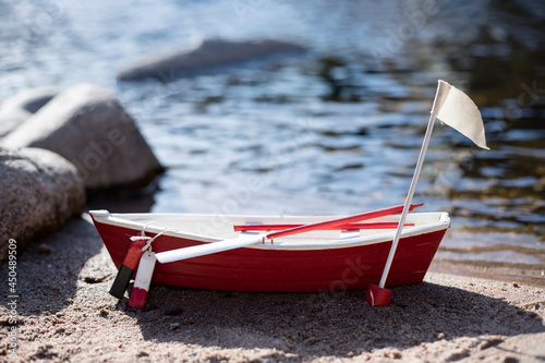 Red miniatur wooden fisherboat at the beach