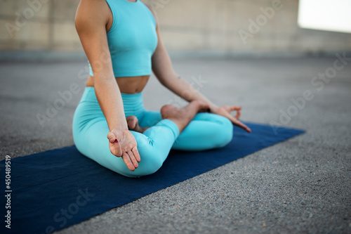 Young woman practising yoga outdoors. Beautiful young girl doing yoga fitness exercise.