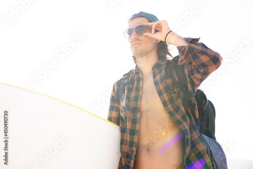 Portrait of surfer with his surfboard. Handsome man at the beach