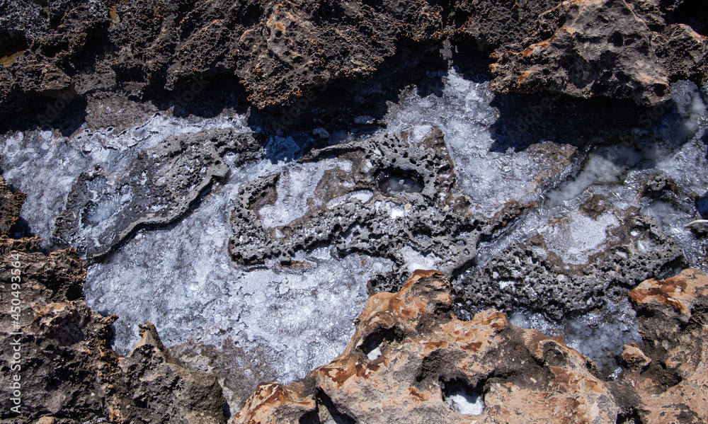 backgrounds and texture on the seashore in stone deposits flooded with water and the remains of sea salt frozen in time backgrounds and texture on the seashore in stone deposits flooded with water and the remains of sea salt frozen in time