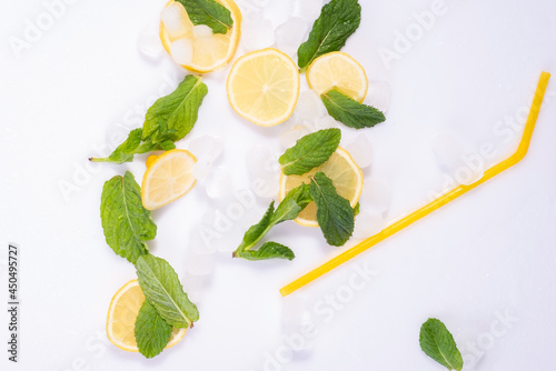 Fototapeta Naklejka Na Ścianę i Meble -  spilled glass of refreshing summer cocktail with ice, lemon and mint on white background