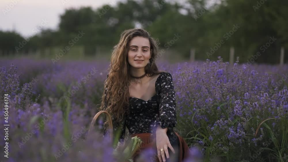 Lovely young woman wearing stylish dress and sitting in purple lavender field Lovely young woman wearing stylish dress and sitting in purple lavender field