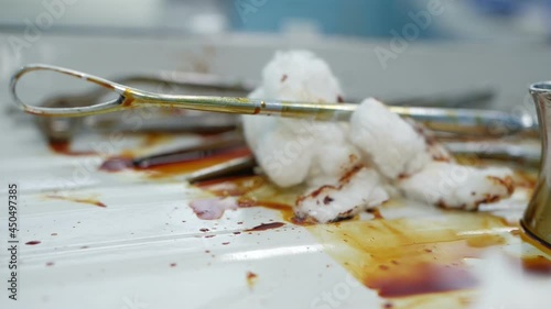 Dirty bloodstained medical utensils and tools on a gloomy table