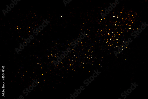 Golden abstract bokeh on black background.