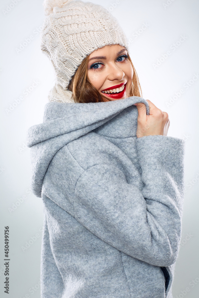 Smiling woman touching collar of her coat.