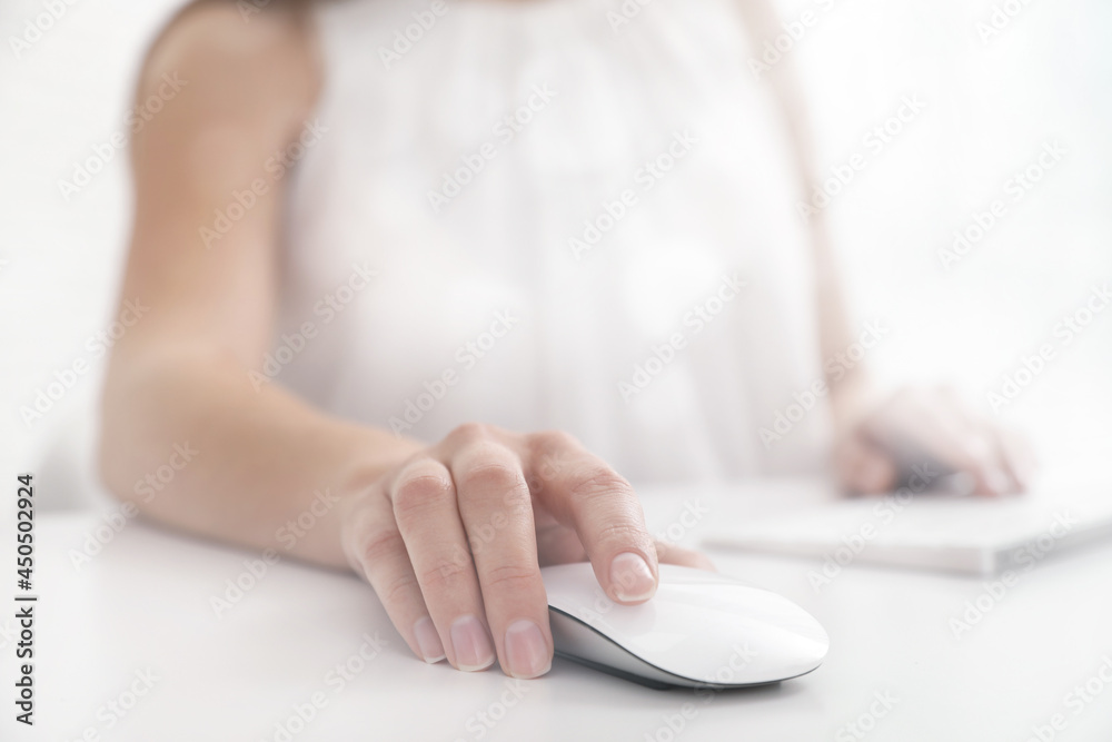 Fototapeta premium Woman using computer mouse at desk, closeup