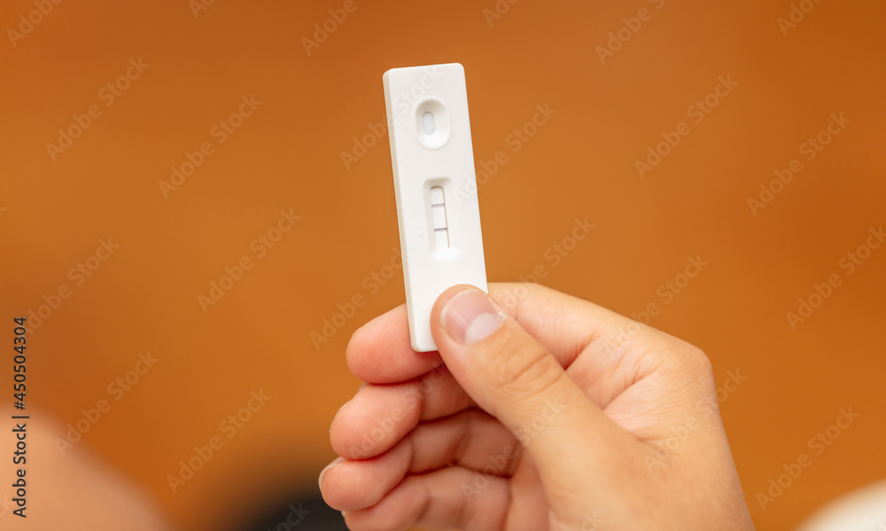 Man hand holding Covid 19 positive result self test.