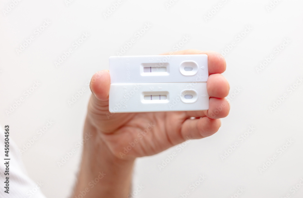 Man hand holding Covid 19 positive and negative result self test. Man hand holding Covid 19 positive and negative result self test.