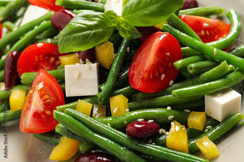 Tasty salad with green beans as background, closeup