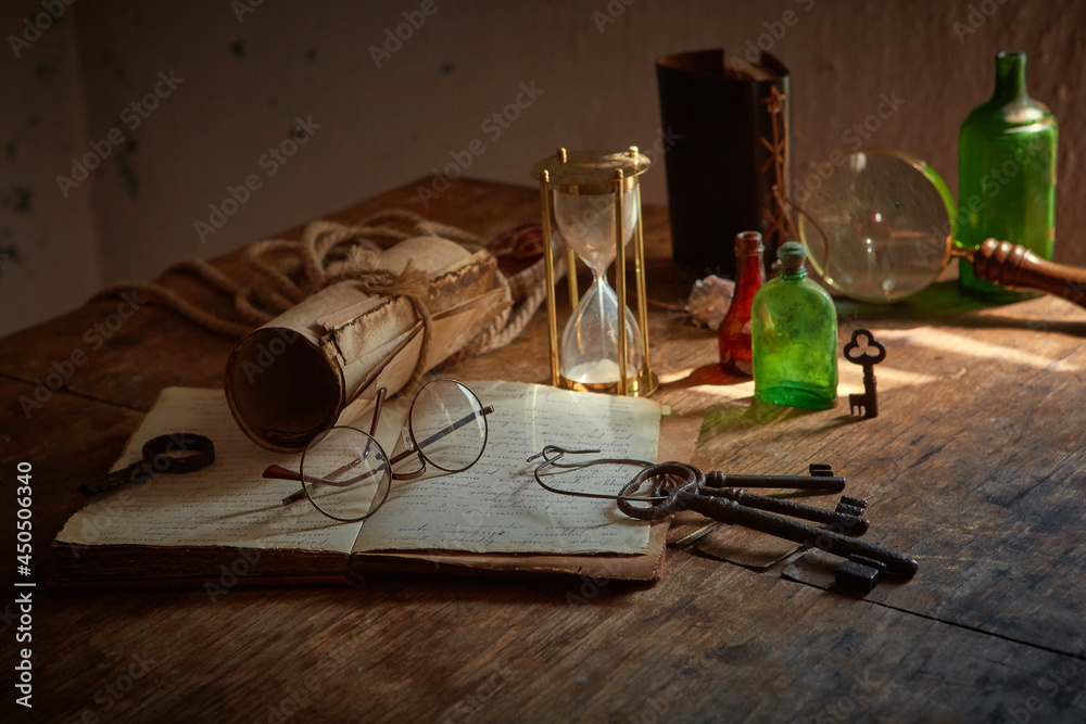 Medicines and substances in glass bottles on an old wooden table. A medieval scientist's room with various flasks and old books.