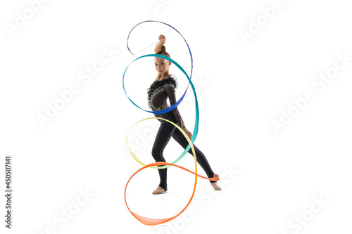 Portrait of little girl, rhythmic gymnastics artist training with colored ribbon isolated on white studio background. Concept of sport, action, aspiration