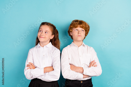 Portrait of two attractive pensive kids folded arms fantasizing isolated over bright blue color background