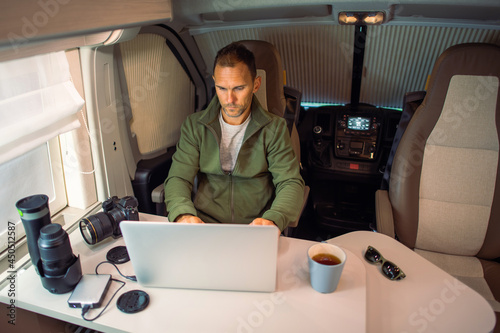 Men Working Remotely From Camper Van Using Internet Connection photo