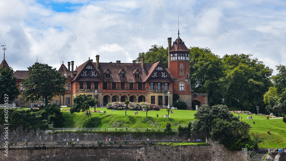 Fototapeta premium San Sebastian, Spain - 2 August 2021: Miramar Palace and Ondaretta Beach from La Concha Bay