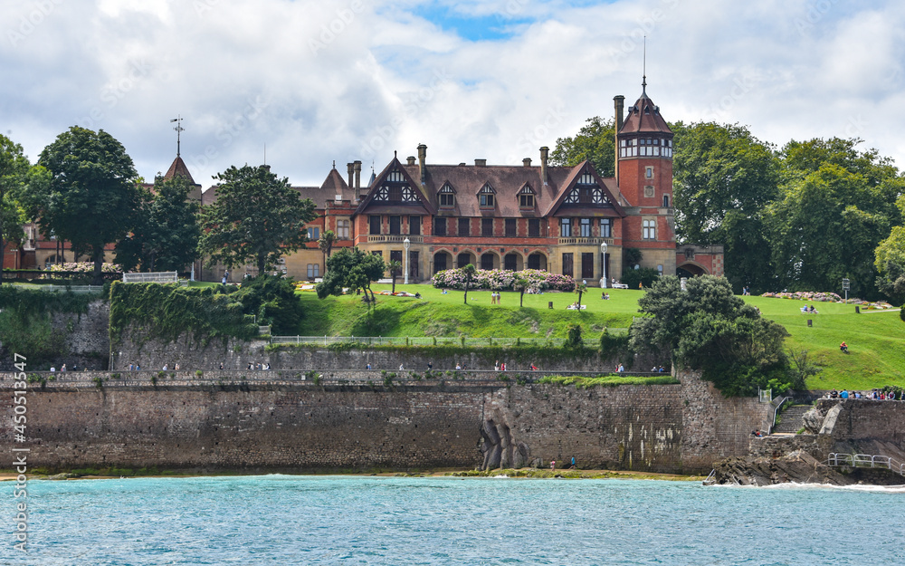 Fototapeta premium San Sebastian, Spain - 2 August 2021: Miramar Palace and Ondaretta Beach from La Concha Bay