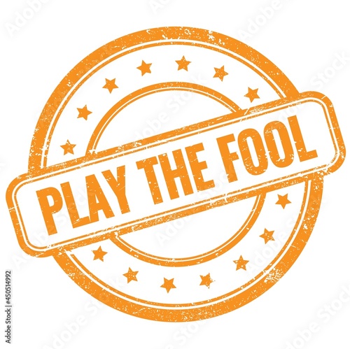 PLAY THE FOOL text on orange grungy round rubber stamp.