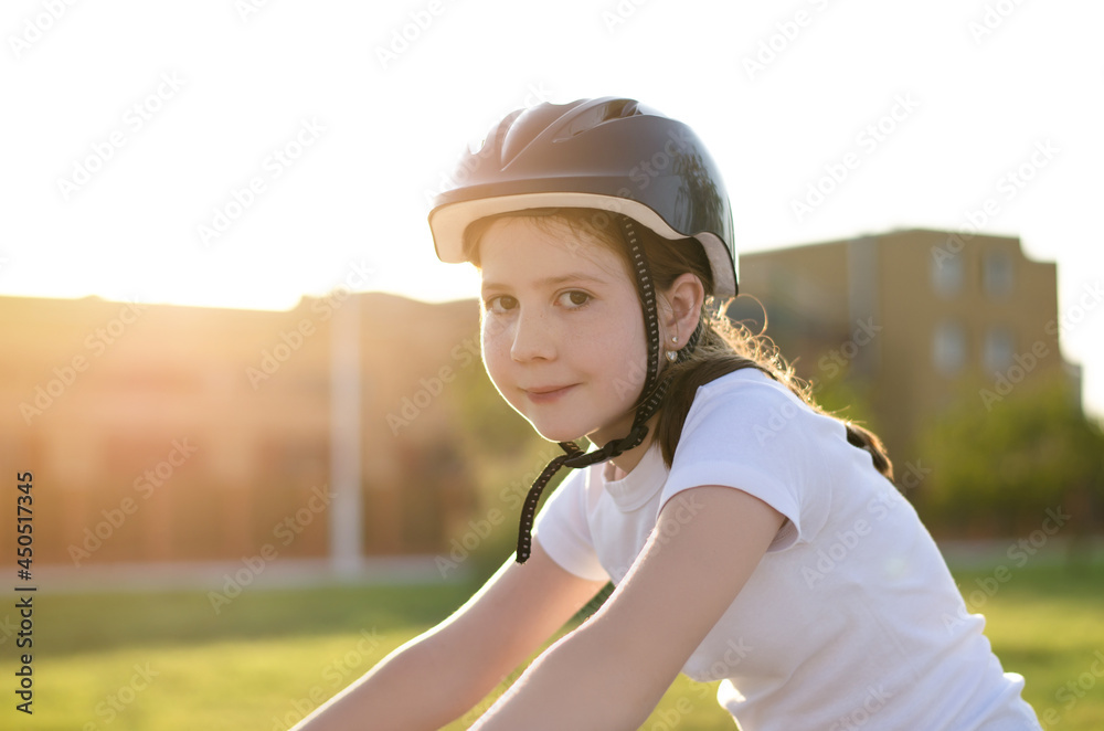 11 year old girl in a helmet rides a bicycle. Girl with a bike in the park. Portrait of a child in a bicycle helmet 11 year old girl in a helmet rides a bicycle. Girl with a bike in the park. Portrait of a child in a bicycle helmet